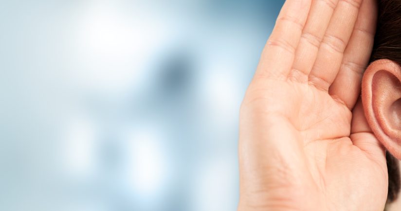 Eine Person hält ihre Hand hinter das Ohr, als ob sie lauschen würde.